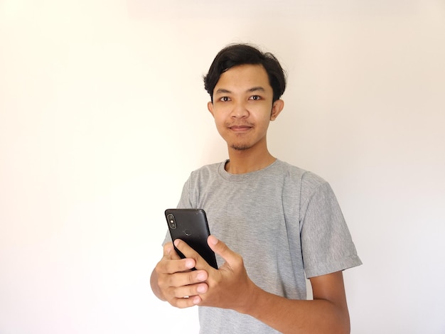 Ух ты и удивленное лицо, азиатский мужчина использует смартфон с копией рекламы