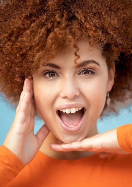 Wow surprise and portrait of a woman with hands for frame isolated on a blue background Smile crazy and face of an African girl with a comic facial expression excited and funny on a backdrop