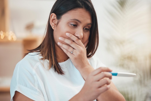 Wow surprise and woman with pregnant test shocked with positive maternity kit result stick in home Thinking anxiety and future mother holding pregnancy test worried pondering and stressed