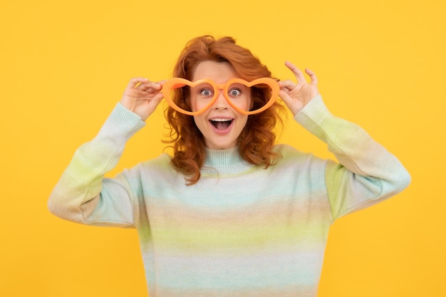 Wow time for fun happy girl wear glasses birthday party celebration express happiness positive emotions cheerful lady on yellow background funny redhead woman in party glasses