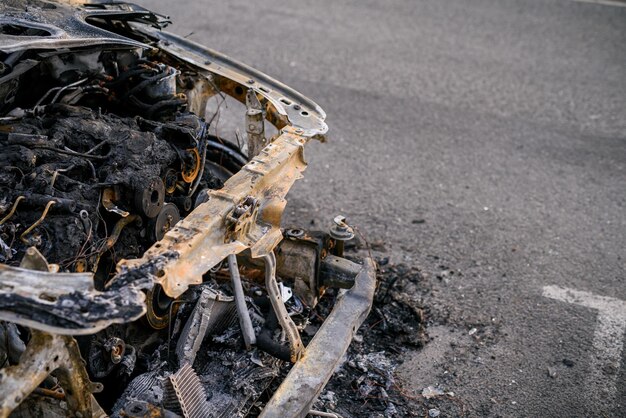 Wrak van verbrande auto aan de kant van de weg