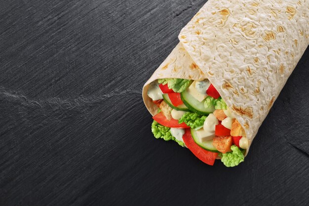 Wrap sandwich met salade, kip, saus, tomaat en augurk