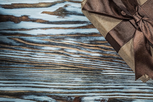 Wrapped brown present box on wooden background