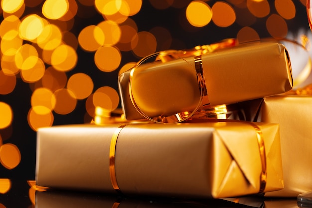 Photo wrapped christmas gifts on golden lights bokeh background close up