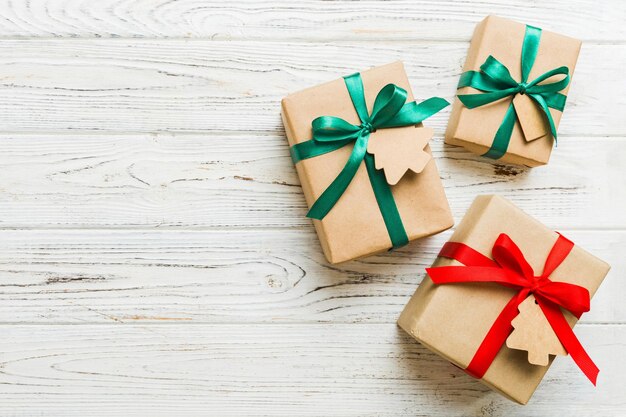 컬러 리본이 있는 종이에 포장된 크리스마스 또는 기타 휴일 수제 선물 복사 공간이 있는 다채로운 테이블 상단 보기에 선물 상자 장식