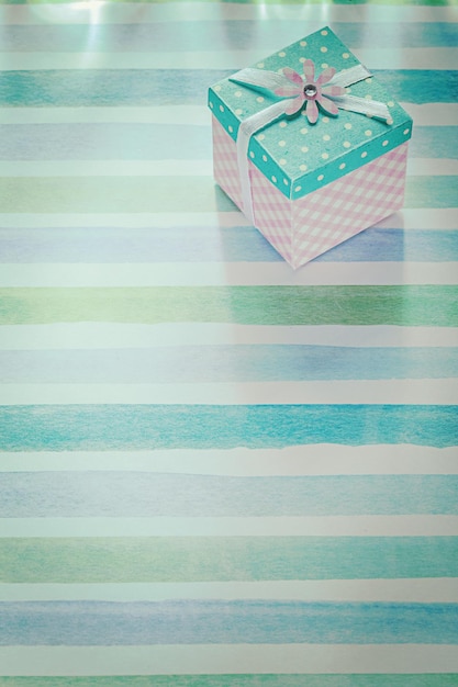 Wrapped gift box on blue striped fabric holidays concept