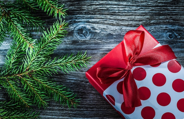 Wrapped gift box fir branches on wooden board