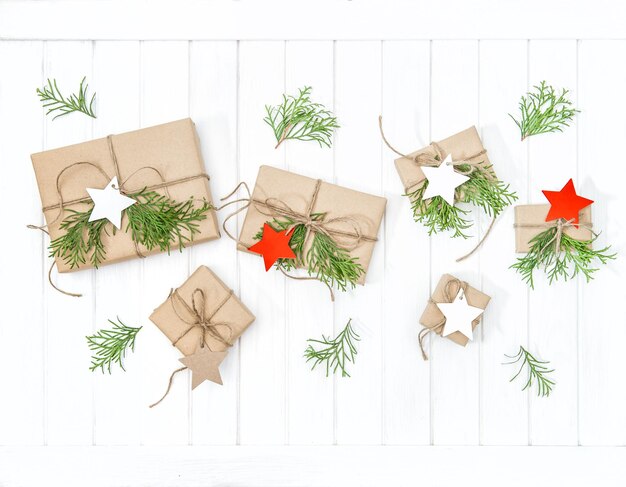 Wrapped gifts with christmas decoration on bright wooden background. Flat lay