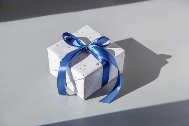 Photo wrapped grey gift box with blue ribbon