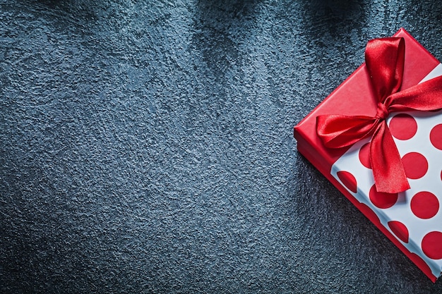 Photo wrapped present box with tied bow on black background holidays concept