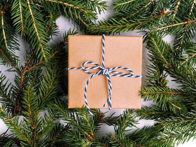 Wrapped vintage gift box with blue ribbon with fir tree branch. Christmas flat lay.