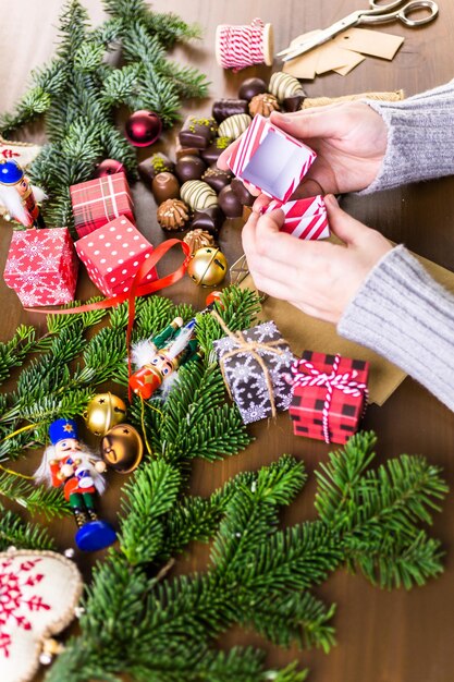 Wrapping assorted chocolates in small boxes for Christmas presents.