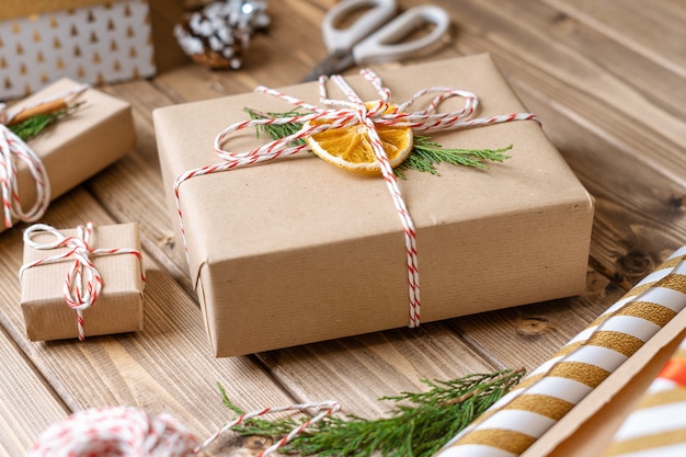 Wrapping christmas gift close up unprepared presents on wooden background with orange cinnamon