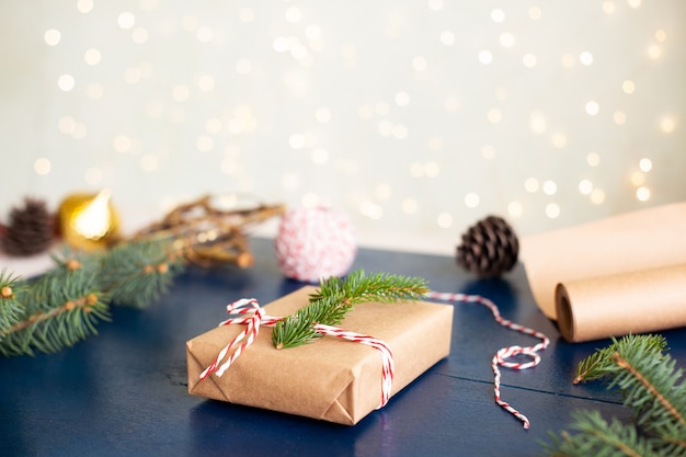 Wrapping of Christmas gifts in  paper and natural materials fir branches on a blue