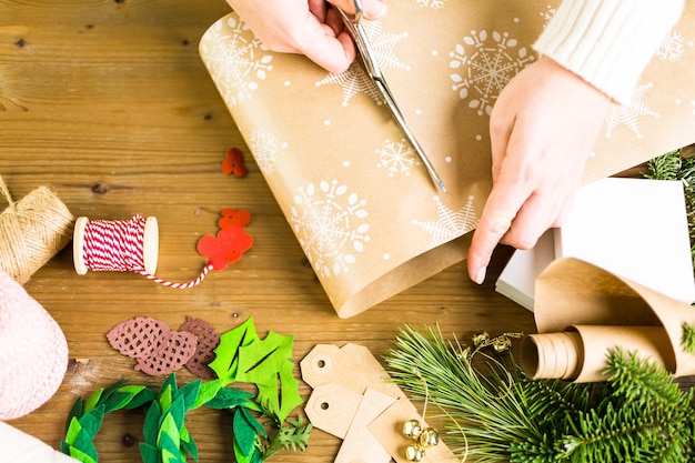 自宅でビンテージスタイルのリサイクルされた茶色の紙でクリスマスプレゼントを包みます。