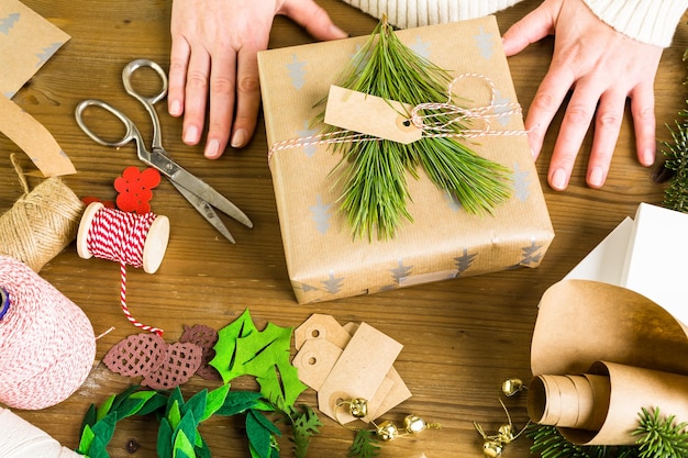 Wrapping Christmas gifts in recycled brown paper with vintage style at home.