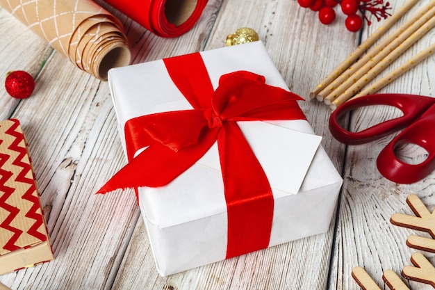  wrapping gift boxes with equipment and decorating items on wooden background