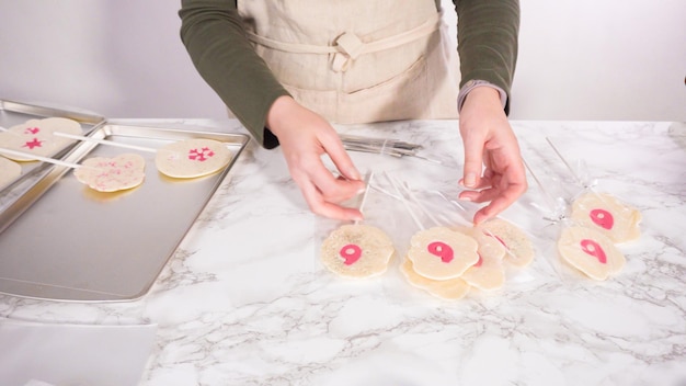 Wrapping large homemade lollipops into clear gift bags.