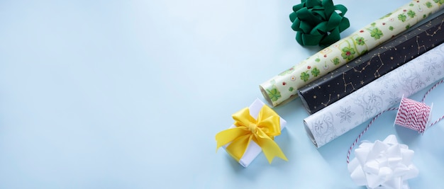 包装紙の弓とリボンは、テキスト用のスペースがある水色の背景のWebバナーにプレゼントを包装する準備ができています