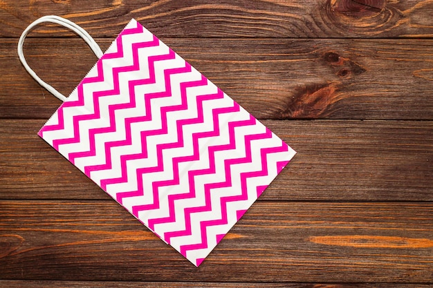 Упаковочная бумага розовый мешок для подарков и на деревянных фоне.
