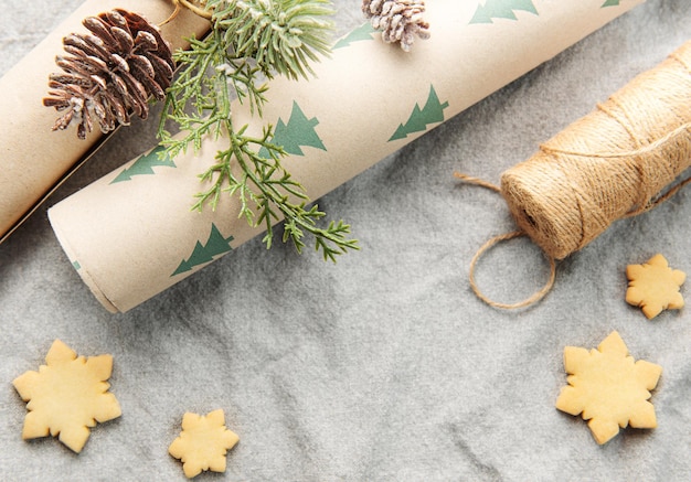 Wrapping paper with a pine branch and Christmas cookies on a textile background