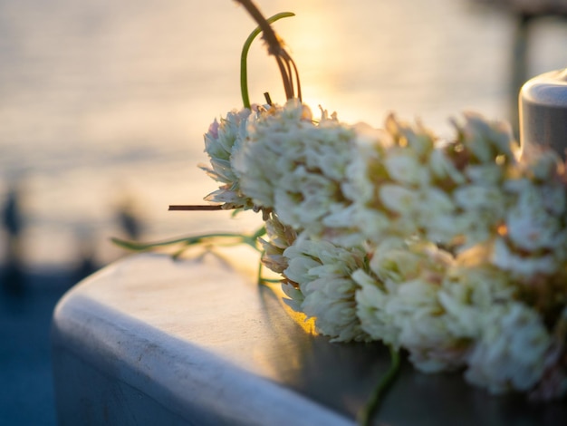 A wreath of flowers closeup against the background of the setting sun Beautiful seascape Abandoned flowers