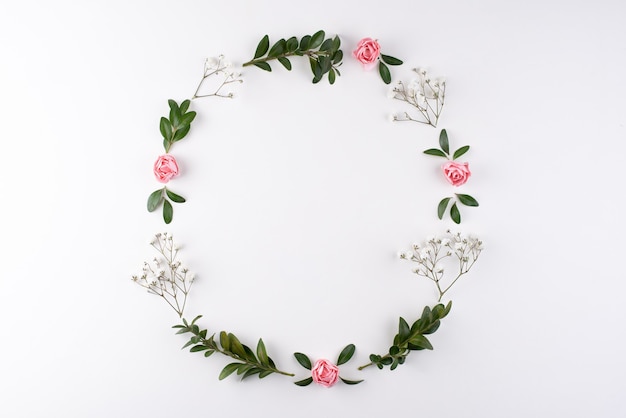 Wreath frame made of flowers branches, eggs and shells, top view, flat lay, close up.