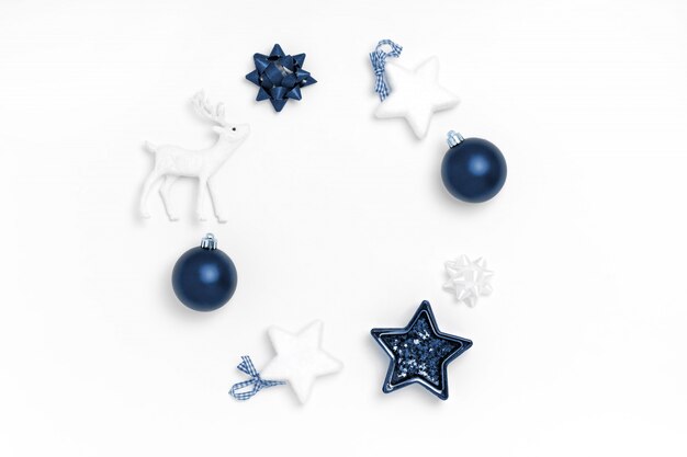 Wreath from blue balls, white stars, deer on white surface