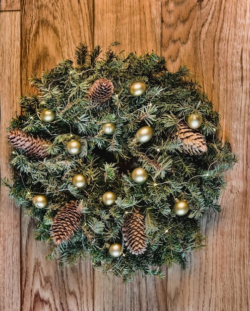 a wreath from branches with cones lights of a garland and gold spheres