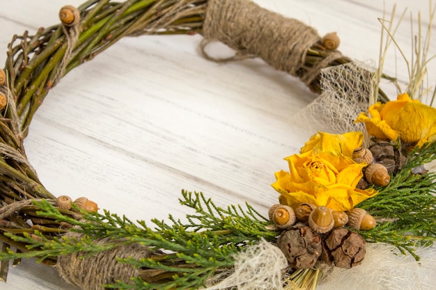 Wreath from a vine with roses. Handmade decor.Wreath of real twigs on a wooden background