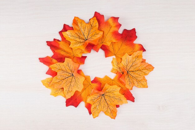 Wreath made of autumn colorful leaves on white background