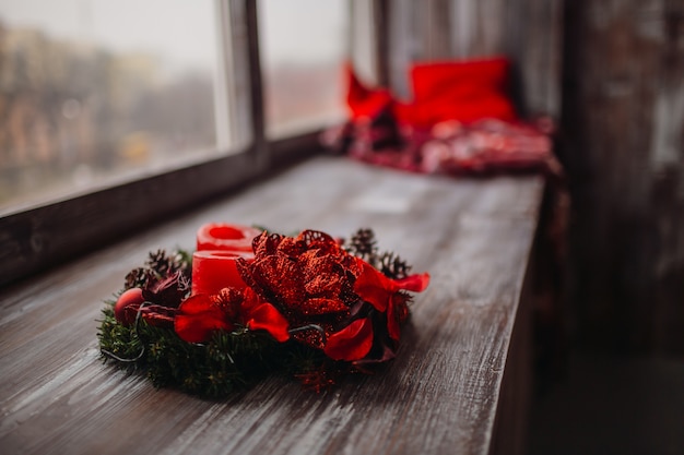 Wreath made of fir branches, red flowers and candles