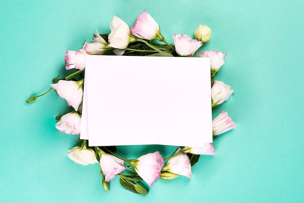 Wreath made of pink flowers eustoma with paper on blue 