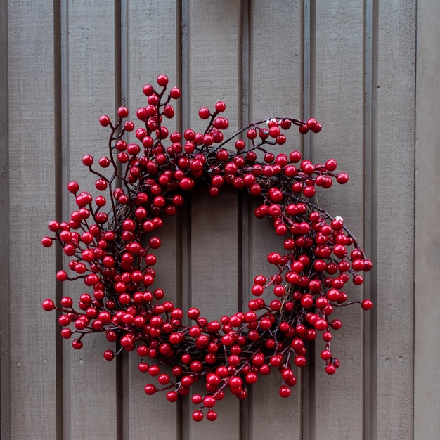 Photo wreath of red berries on a wooden brown background