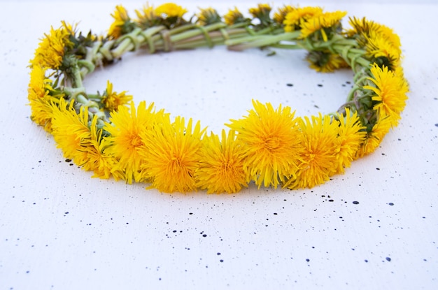 白い背景の上の黄色のタンポポの花輪