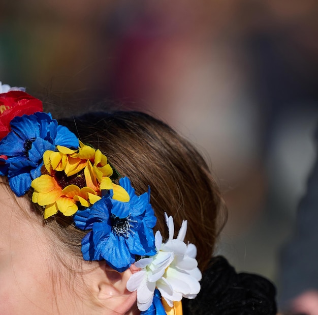 A wreath of yellowblue artificial flowers on a girl's head