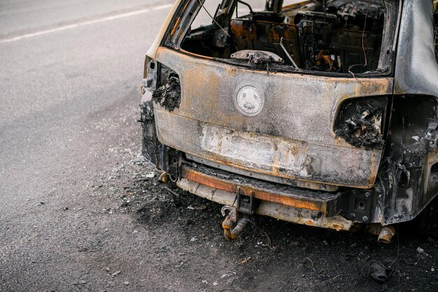 Wreck of burned car on the side of the road