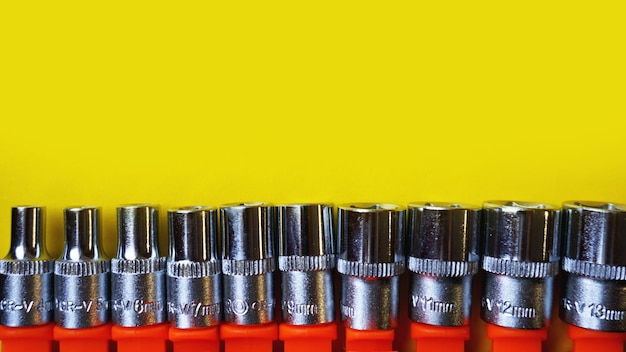 Wrench head bits for the screwdriver and other tools on bright yellow background, top view