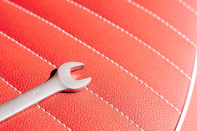 A wrench on the leather seat of a motorcycle during repair