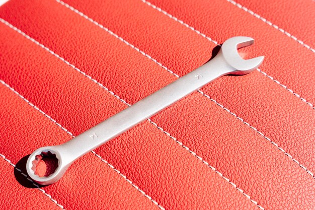 A wrench on the leather seat of a motorcycle during repair