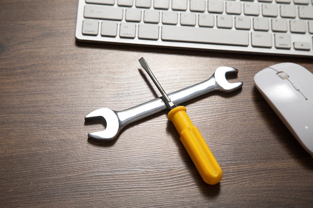 Wrench and screwdriver with a computer keyboard IT Service Support