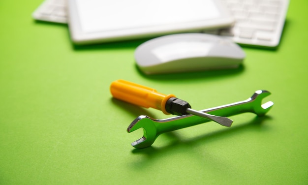 Wrench and screwdriver with a computer keyboard IT Service Support
