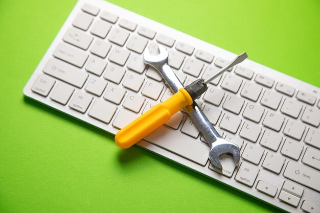 Wrench and screwdriver with a computer keyboard IT Service Support