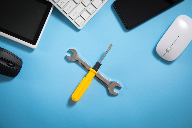 Wrench and screwdriver with a computer keyboard smartphone tablet mouse IT Service Support