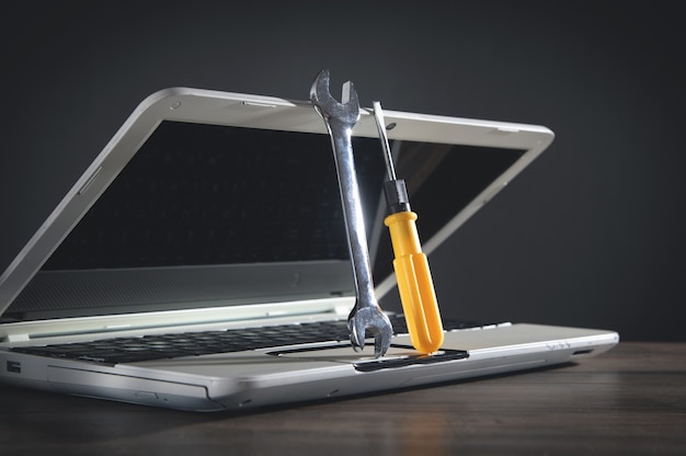 Photo wrench and screwdriver with a laptop computer. it service. support