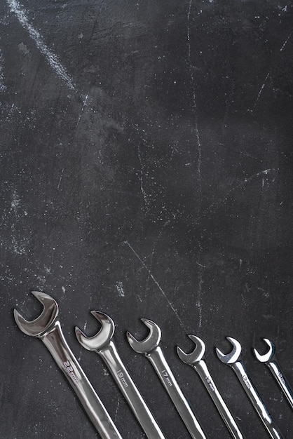 Wrenches on black background with copy space in the center, steel hand working tools