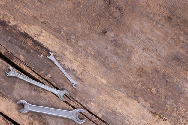 Wrenches on old wooden boards background