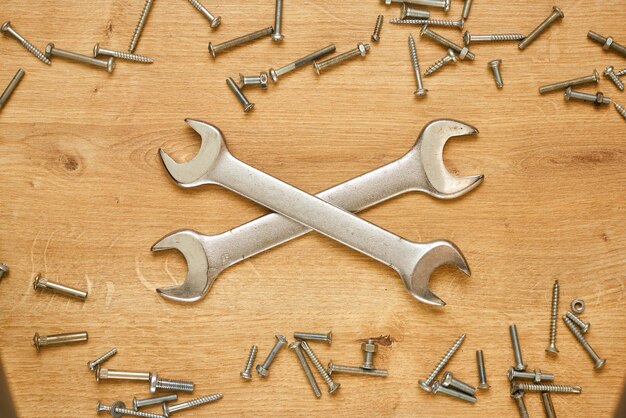 Photo wrenches and screws on a wooden table.