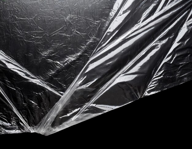 Photo wrinkled plastic wrap texture on dark black background