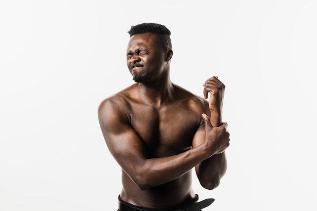 Wrist injury of muscular african american man on white background Traumatology African american man with pain and bruise in his arm due to an accident